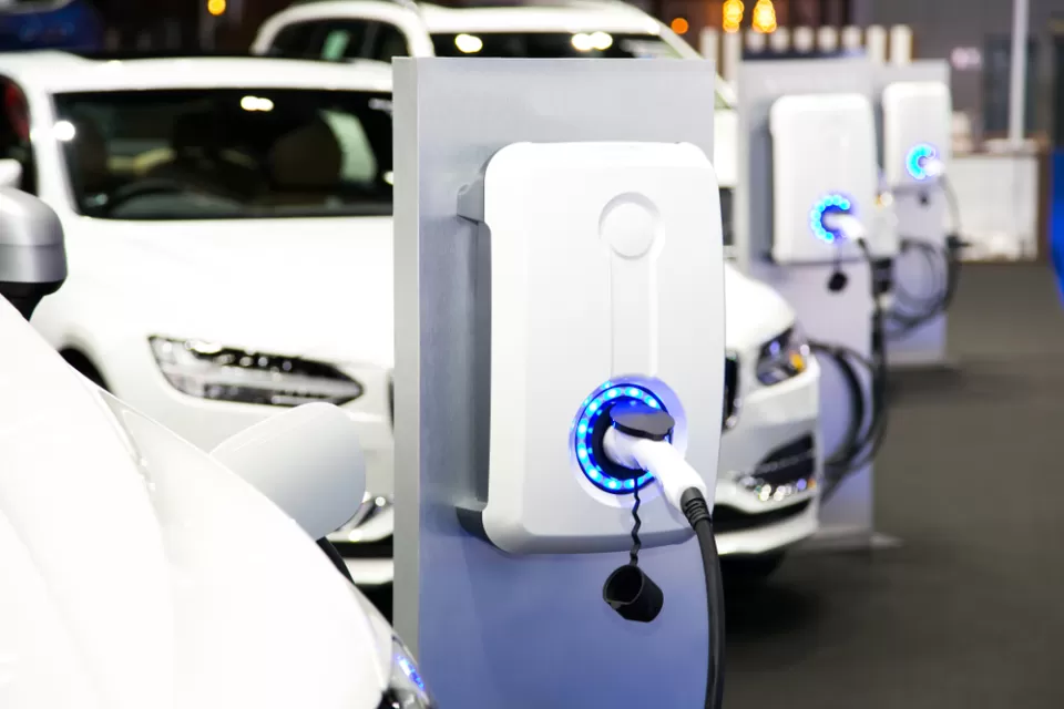 Row of white electric cars at charging station